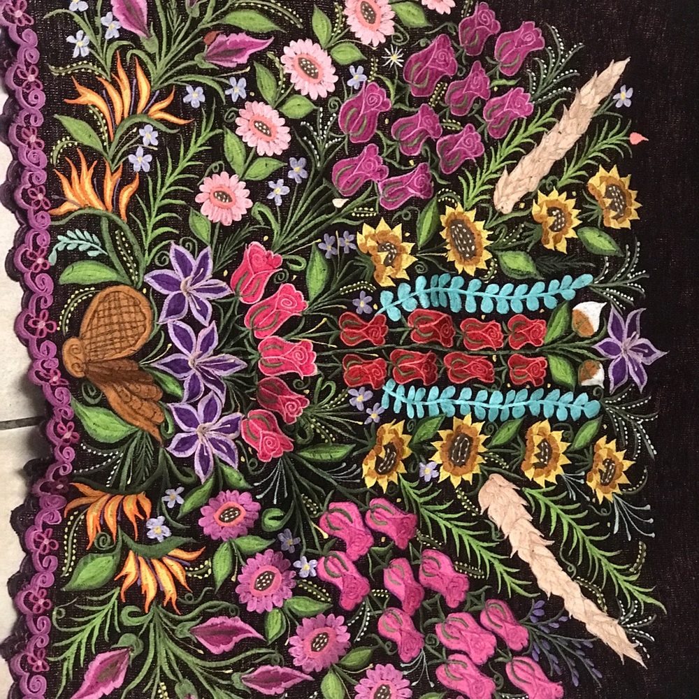 Embroidered material with hand stitched flowers.